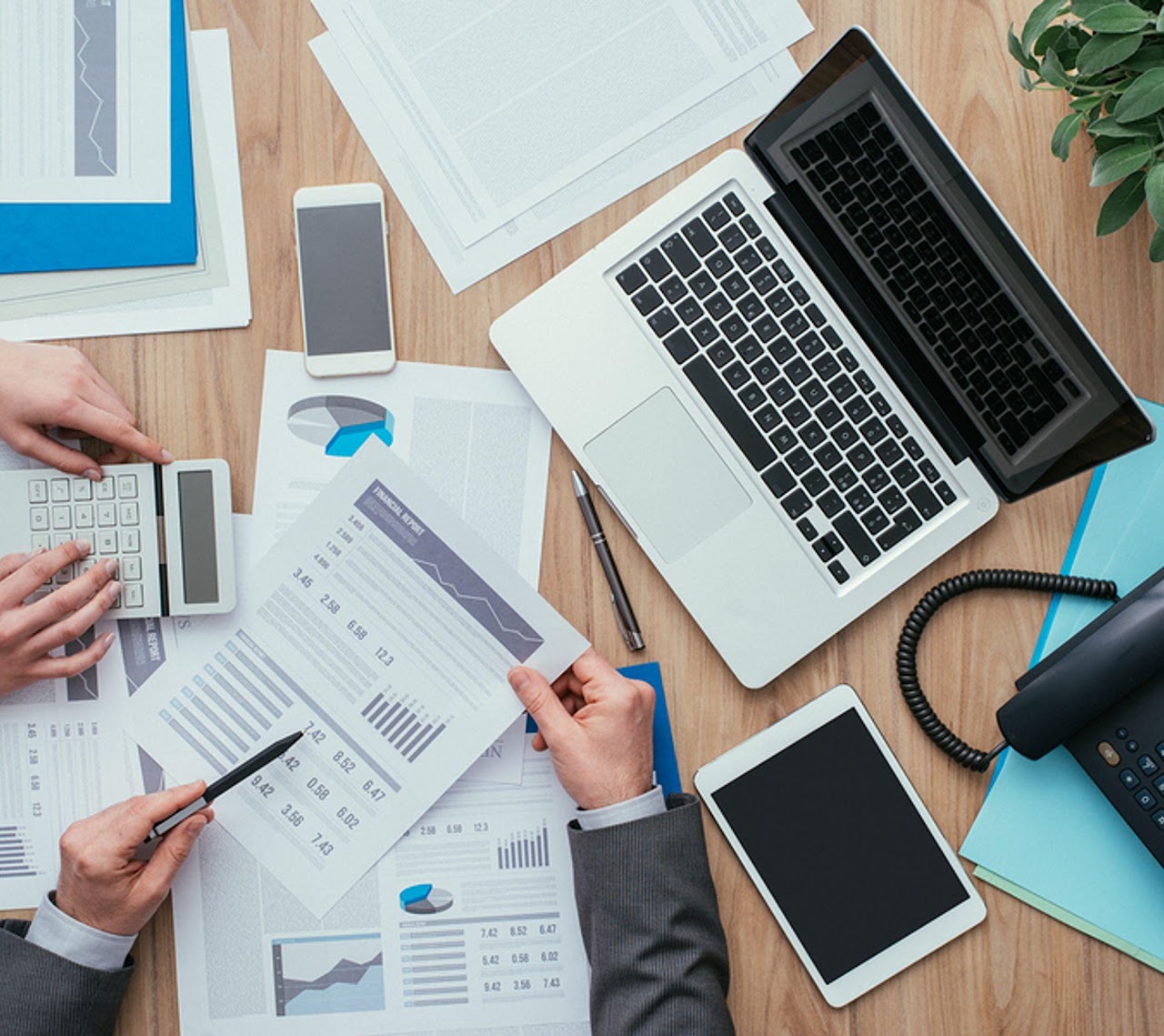 Financial reports being reviewed together at a desk